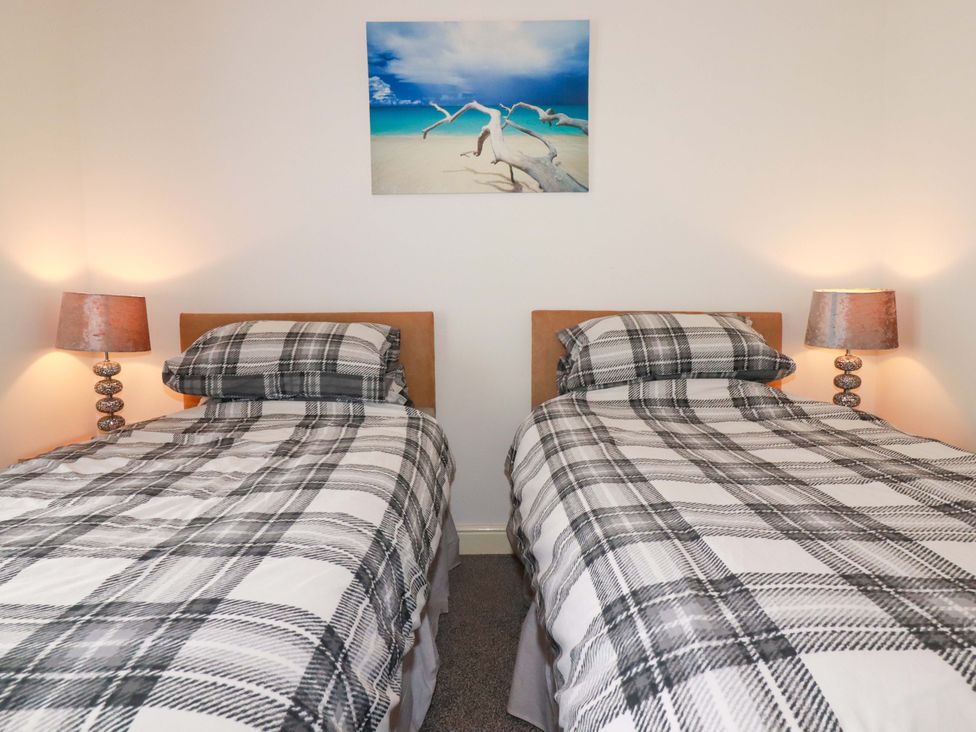 A bedroom with twin beds and lamps at Meadow Retreat in Wadebridge