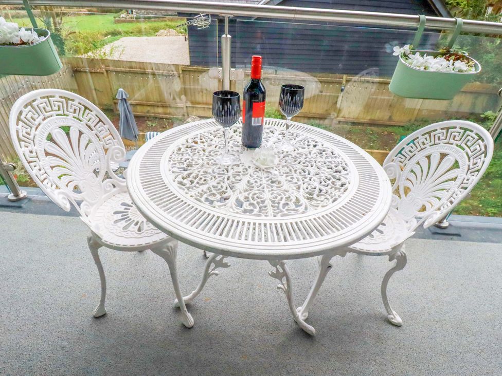 A table with wine and glasses on a balcony at Meadow Retreat in Wadebridge