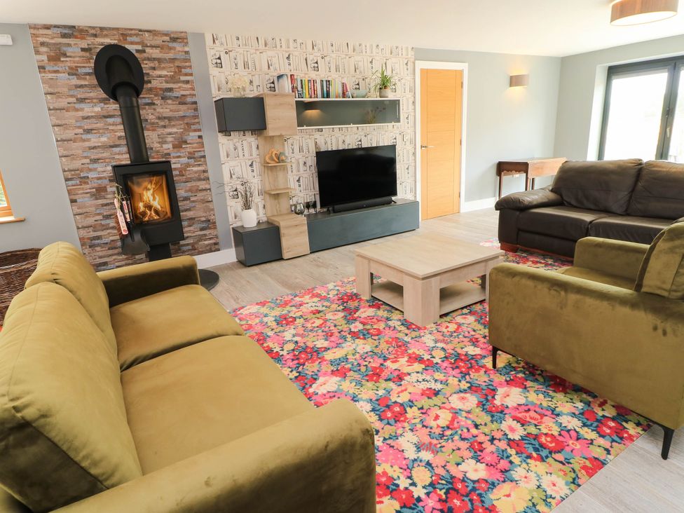 A living room with a fireplace and seating at Hazeldene near Harvington