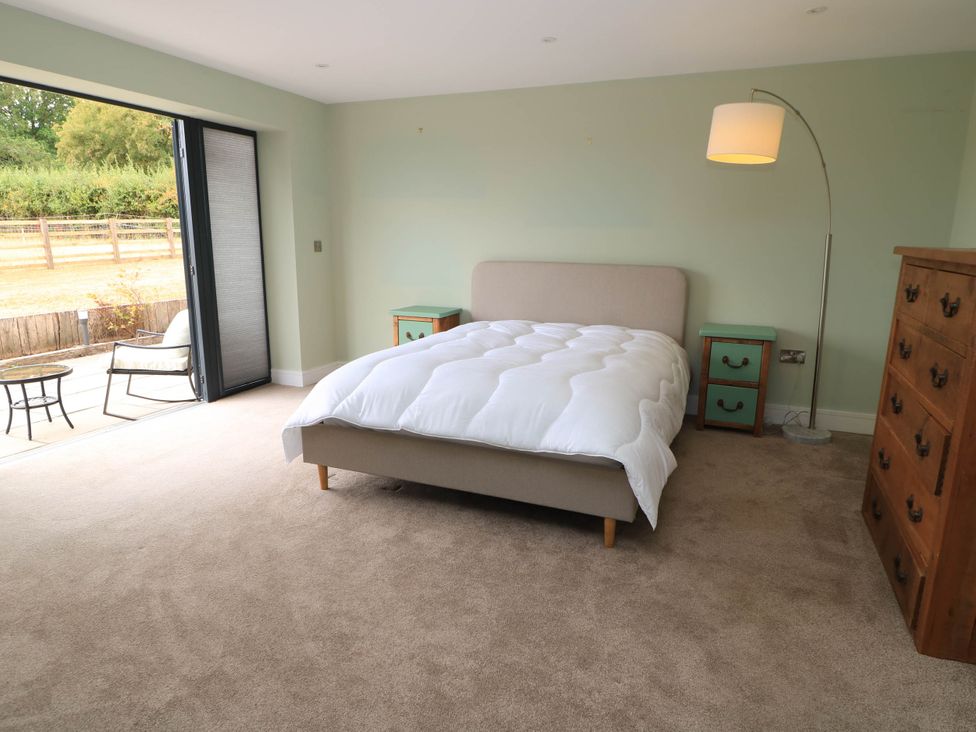 A bedroom with a bed and drawer chest at Hazeldene near Harvington