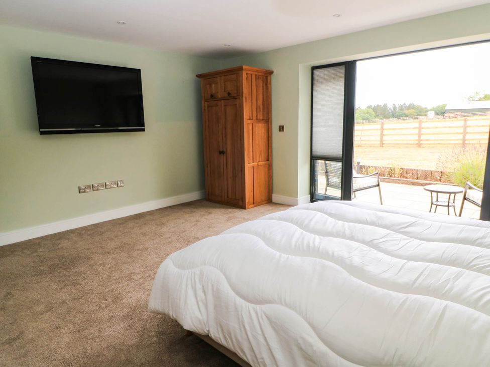 A bedroom with a bed and a wardrobe at Hazeldene near Harvington