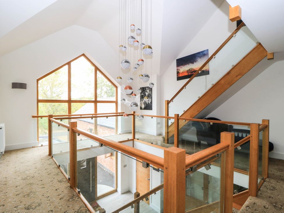 A hallway with a staircase and window at Hazeldene near Harvington