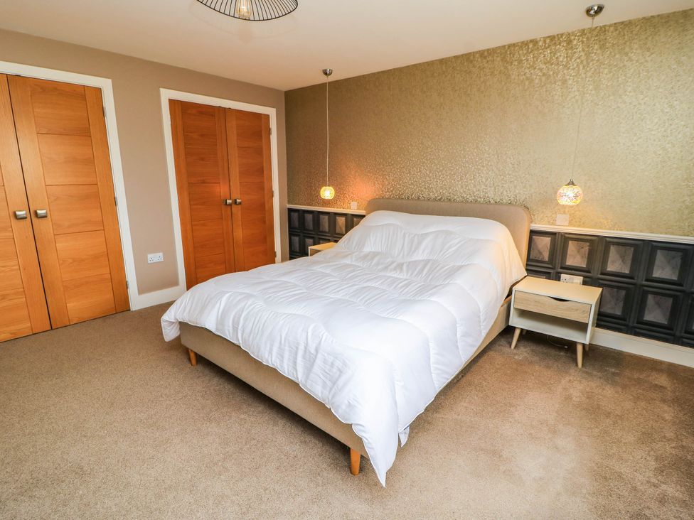 A bedroom with a bed and nightstand at Hazeldene near Harvington