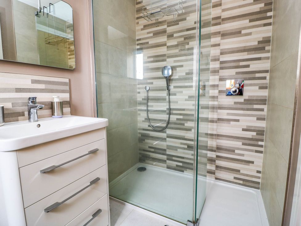A bathroom with a shower, sink, and mirror at Hazeldene near Harvington