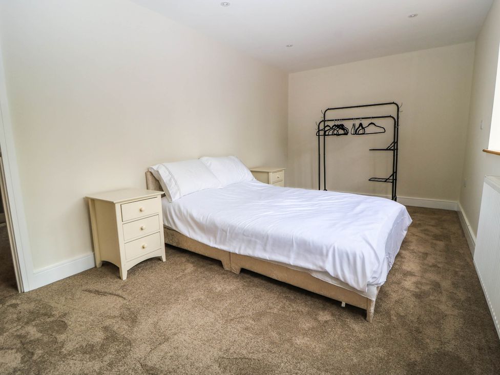 A bedroom with a bed and nightstand at Hazeldene near Harvington