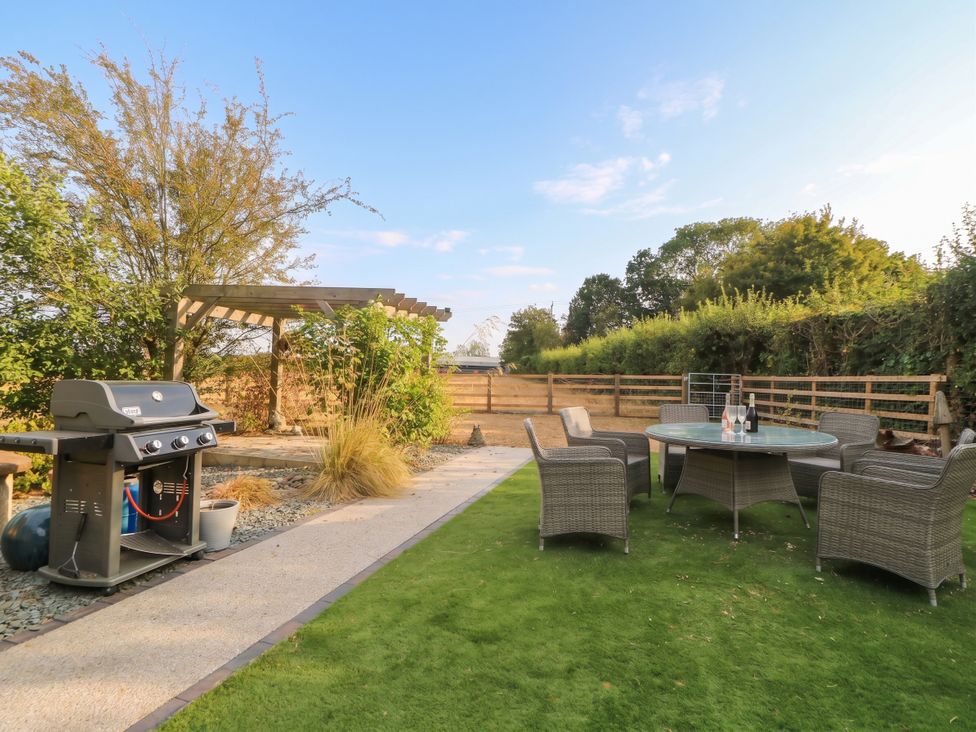 A garden with a grill and seating area at Hazeldene near Harvington