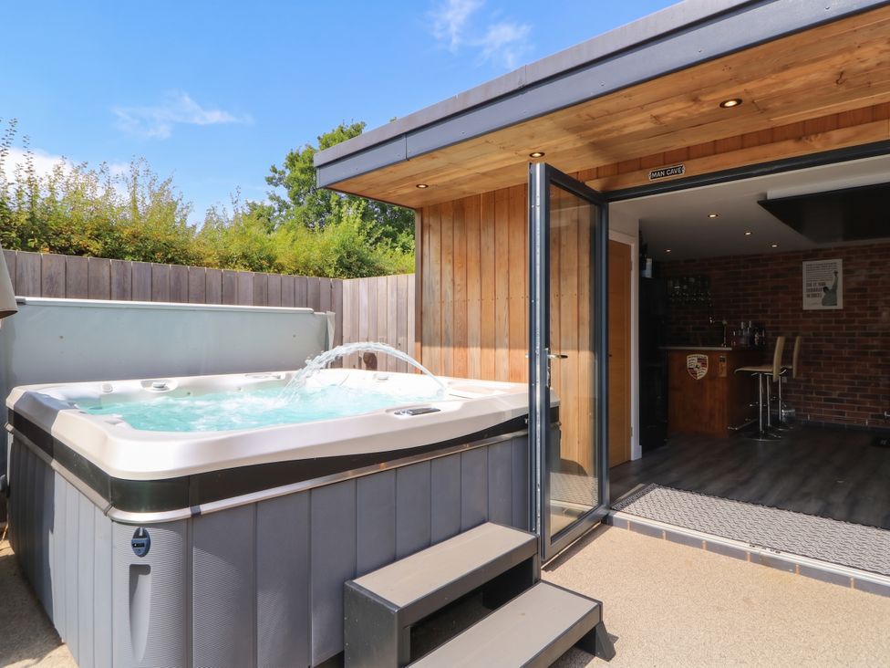 An outdoor area with a hot tub and bar counter at Hazeldene near Harvington