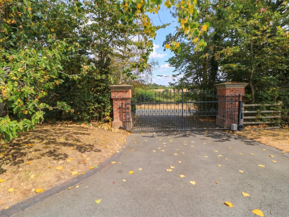 A gated entrance with brick pillars at Hazeldene near Harvington