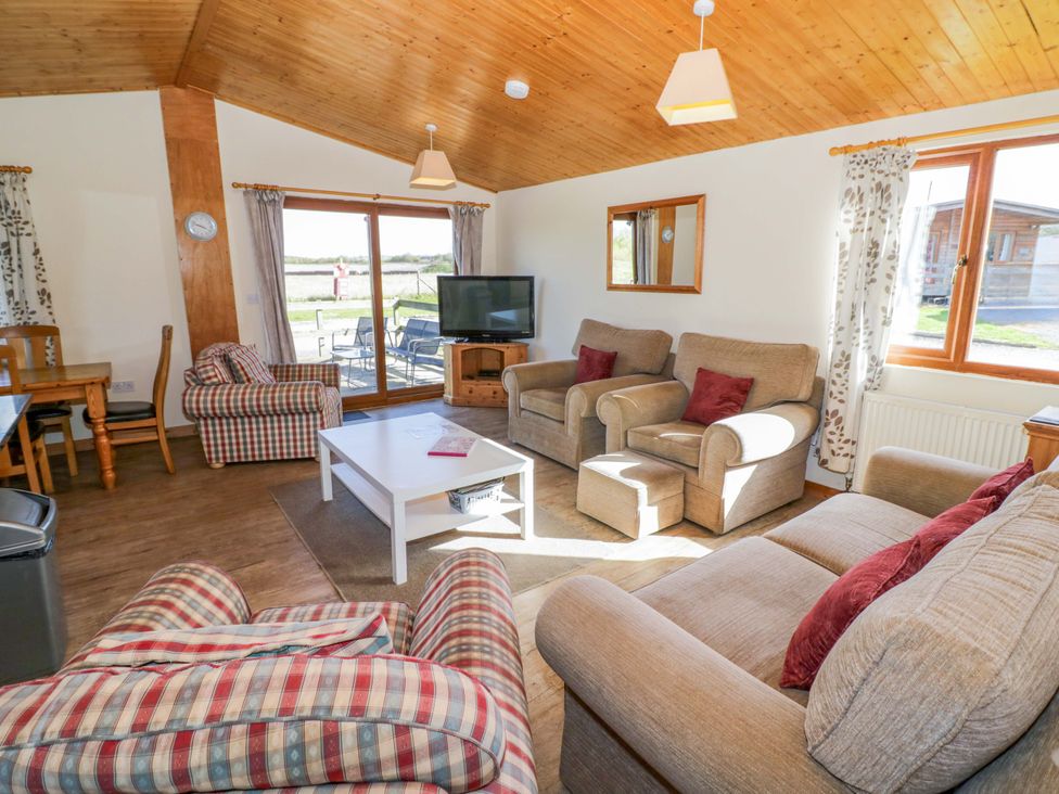 A living room with a sofa and television at Lavender Lodge in Evesham