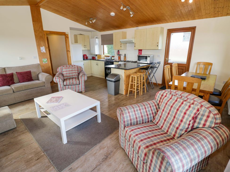 A living room with a sofa and dining area at Lavender Lodge Evesham