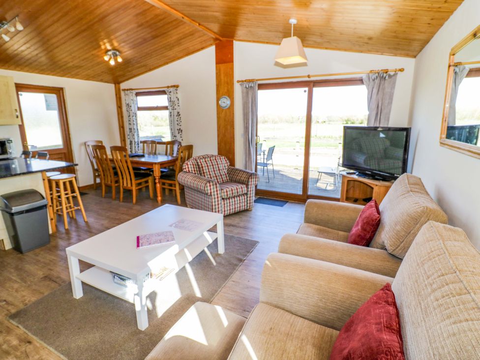 A living room with a sofa and dining table at Lavender Lodge in Evesham