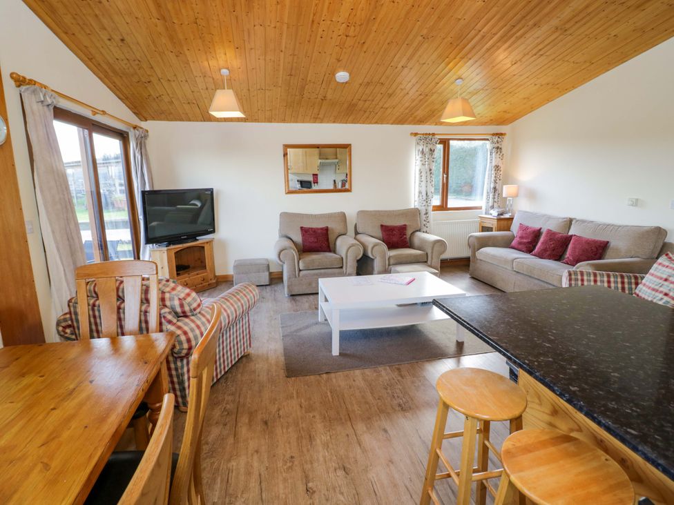 A living room with a sofa and dining table at Lavender Lodge Evesham
