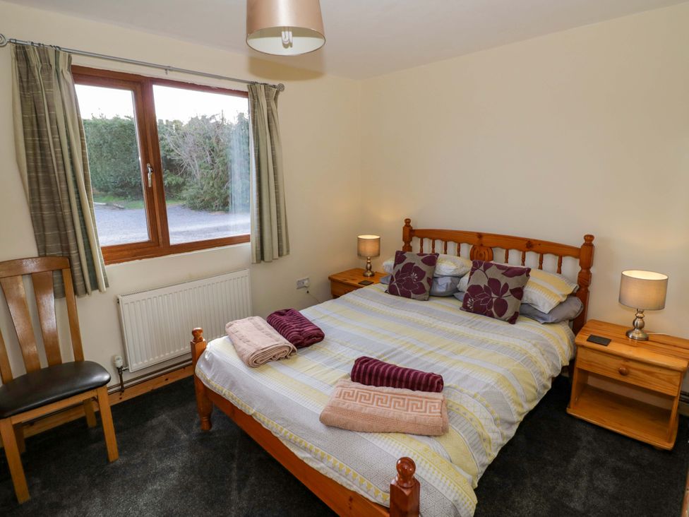 A bedroom with a double bed and window at Lavender Lodge Evesham