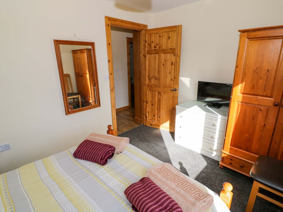 A bedroom with a bed and wardrobe at Lavender Lodge Evesham