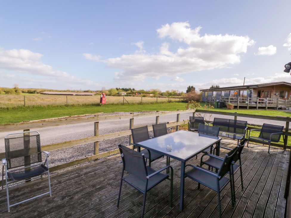 An outdoor seating area with a table and chairs at Lavender Lodge in Evesham