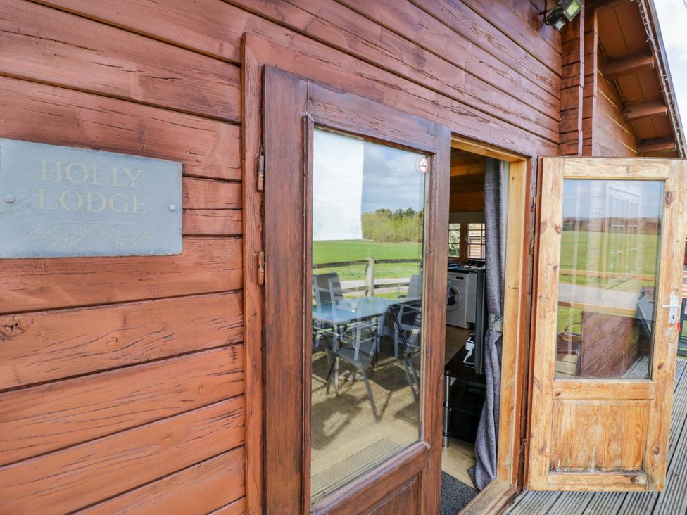 An entryway with a sign and view of seating area at Holly Lodge in Evesham