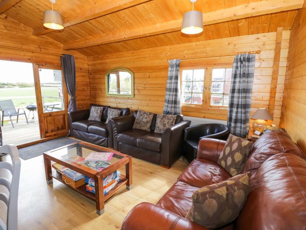 A living room with sofas and a coffee table at Holly Lodge in Evesham
