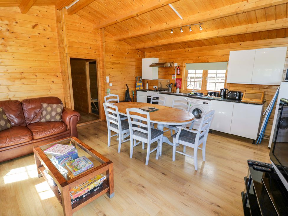 A kitchen with dining table and sofa at Holly Lodge Evesham