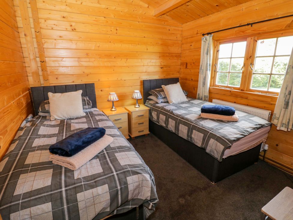 A bedroom with two beds and nightstands at Holly Lodge in Evesham