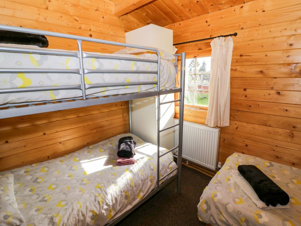 A bedroom with a bunk bed and a single bed at Holly Lodge Evesham