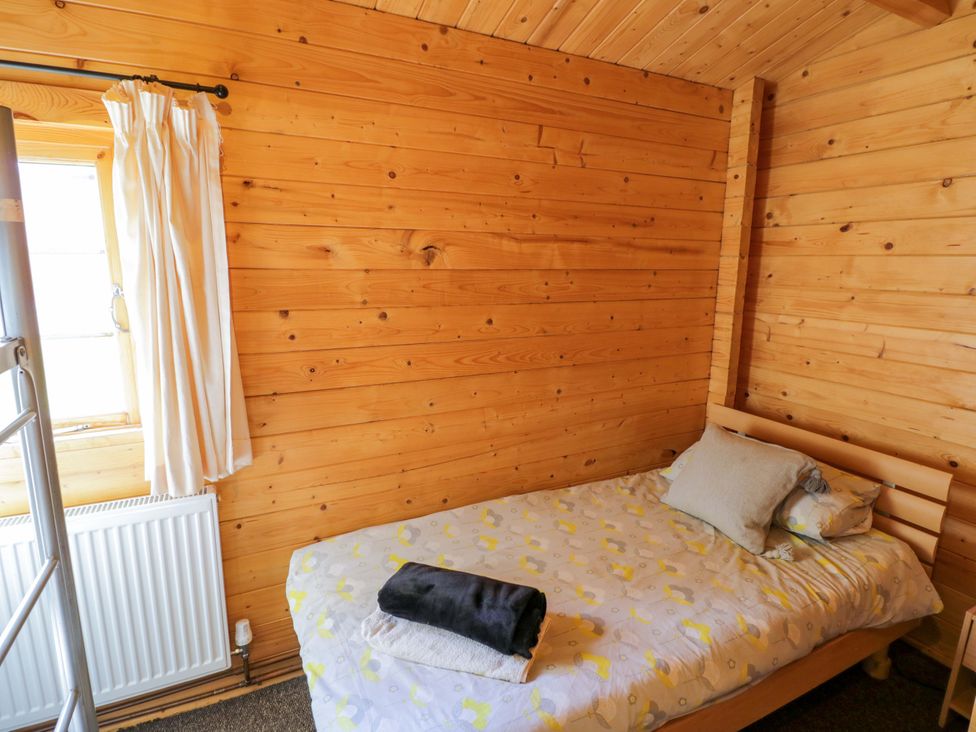 A bedroom with a bed and window at Holly Lodge Evesham
