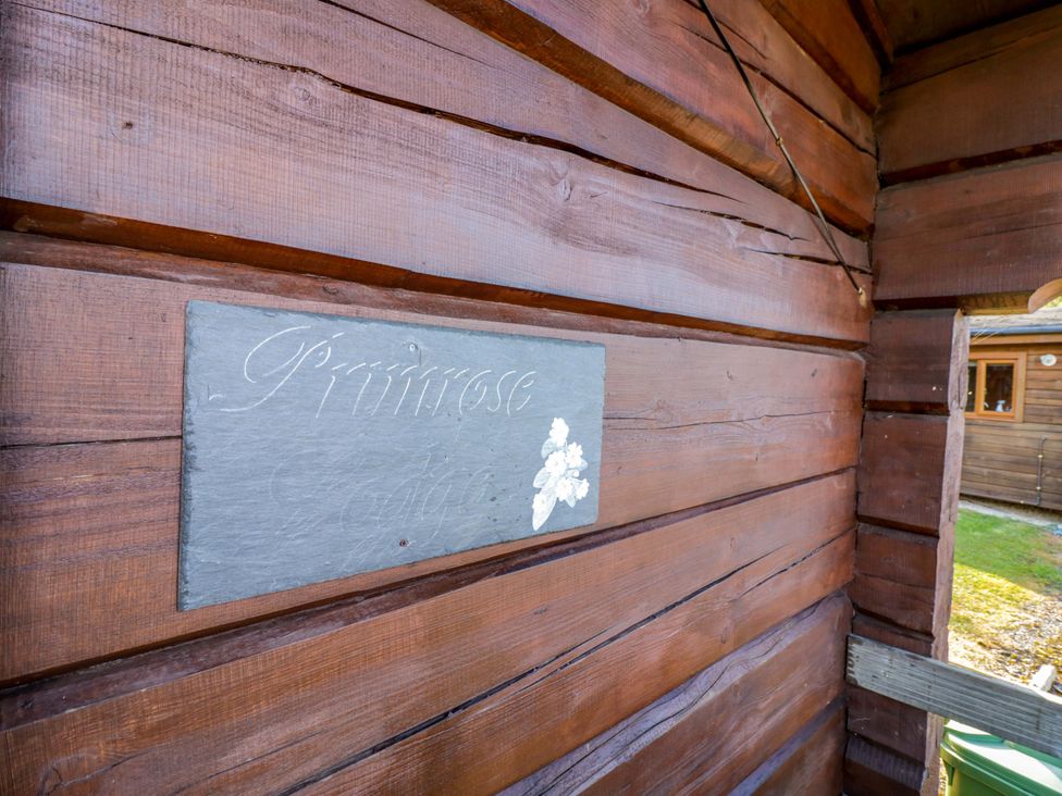 A wooden wall with a slate sign at Primrose Lodge Offenham