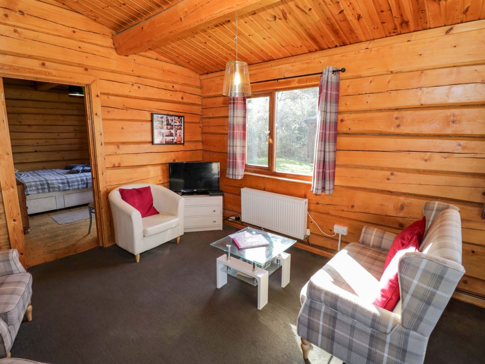 A living room with a sofa and TV at Primrose Lodge in Offenham