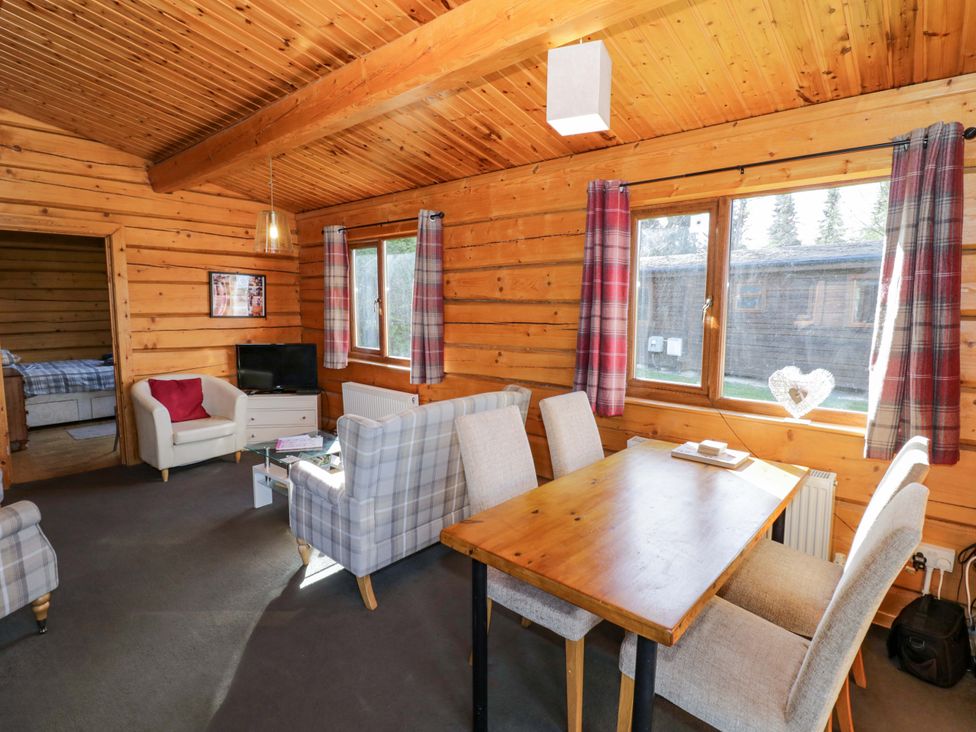 A dining room with a table and chairs at Primrose Lodge Offenham