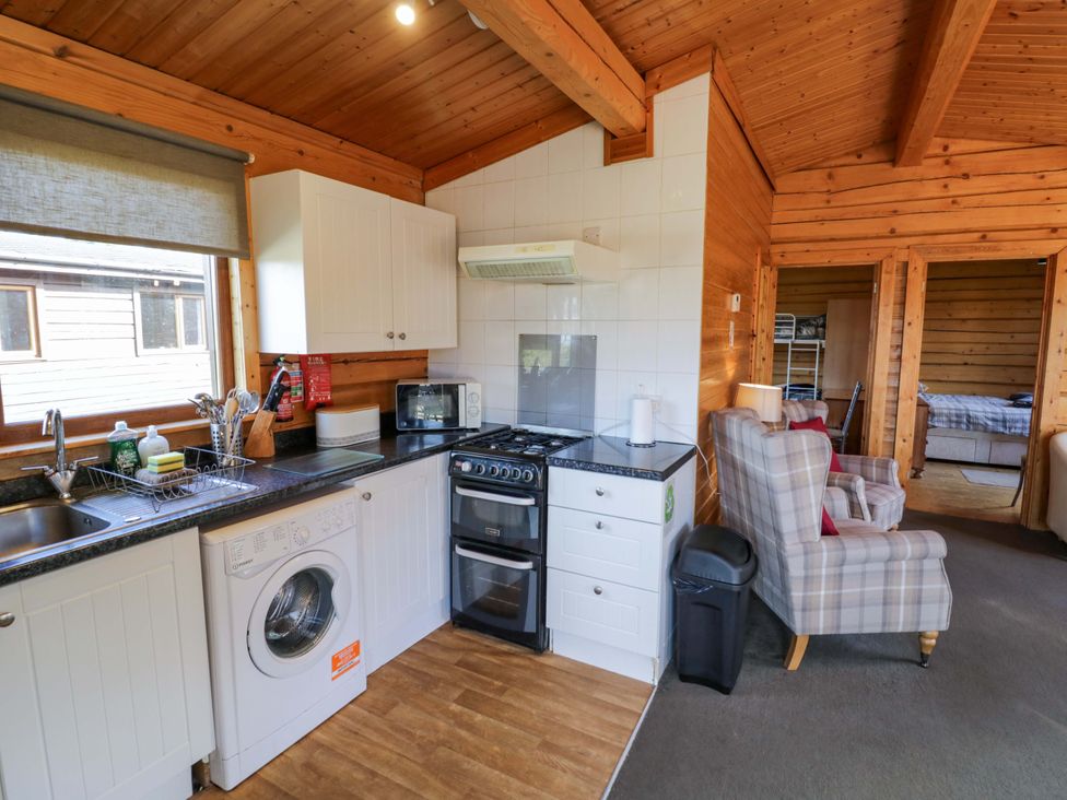 A kitchen with washing machine and stove at Primrose Lodge Offenham