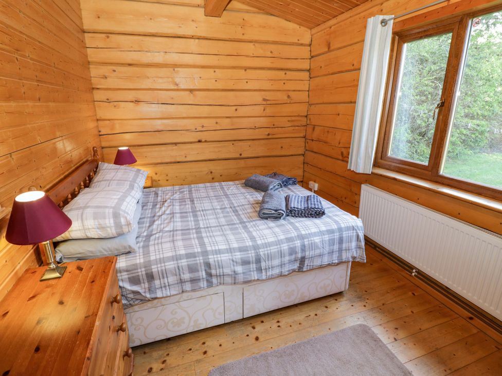 A bedroom with a bed and side lamps at Primrose Lodge in Offenham