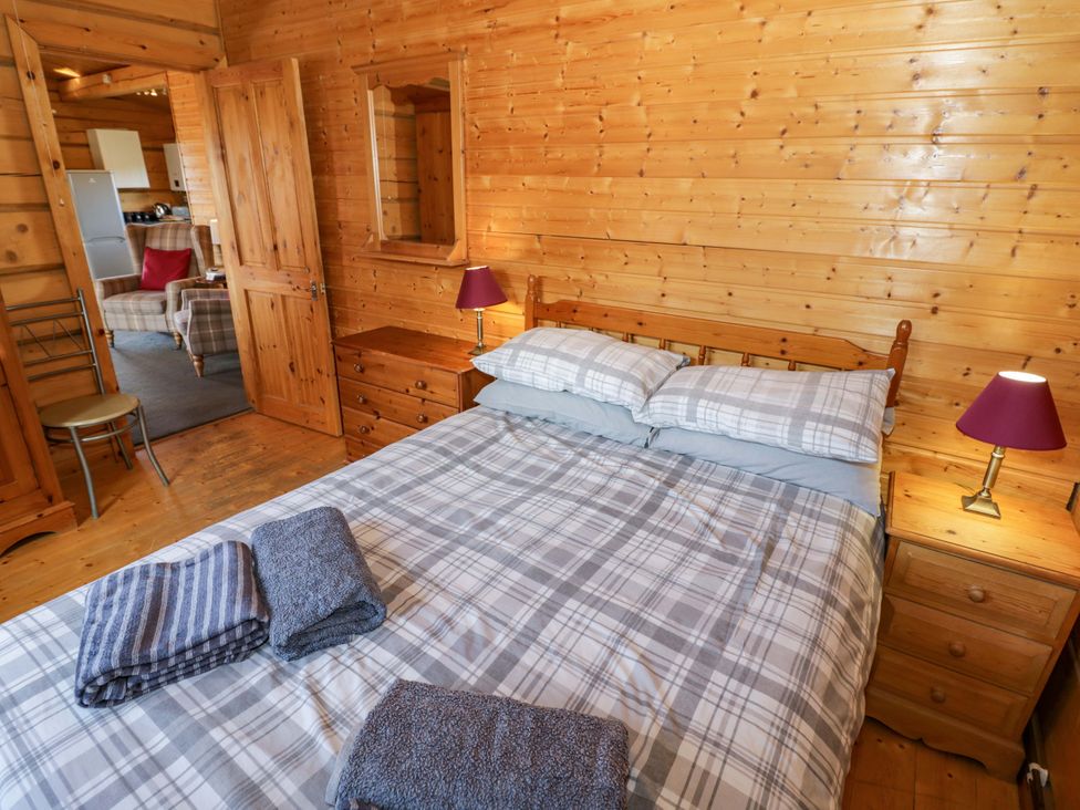 A bedroom with a bed and dresser at Primrose Lodge Offenham