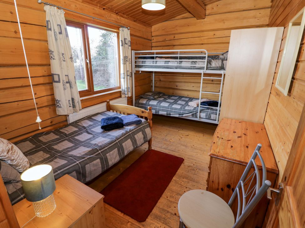 A bedroom with a bed and bunk bed at Primrose Lodge Offenham