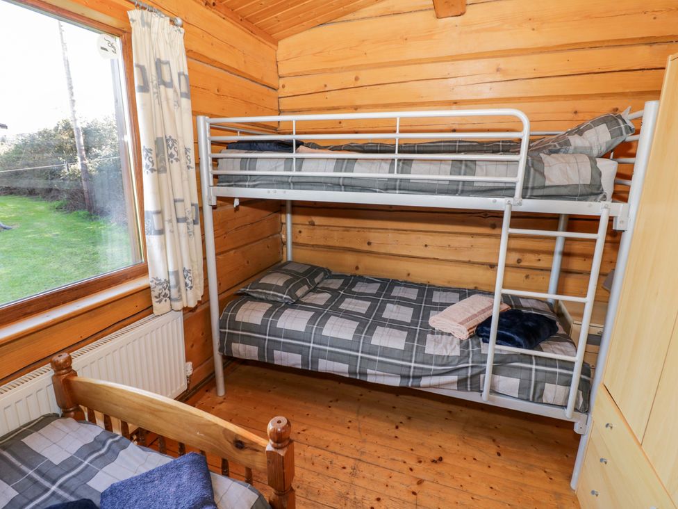 A bedroom with a bunk bed and a single bed at Primrose Lodge Offenham