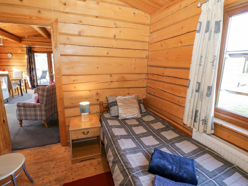 A bedroom with a single bed and a side table at Primrose Lodge Offenham