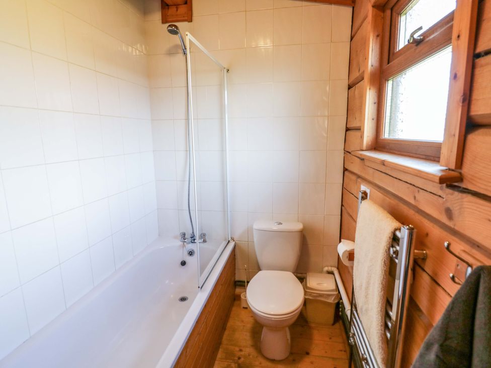 A bathroom with a bathtub and toilet at Primrose Lodge Offenham