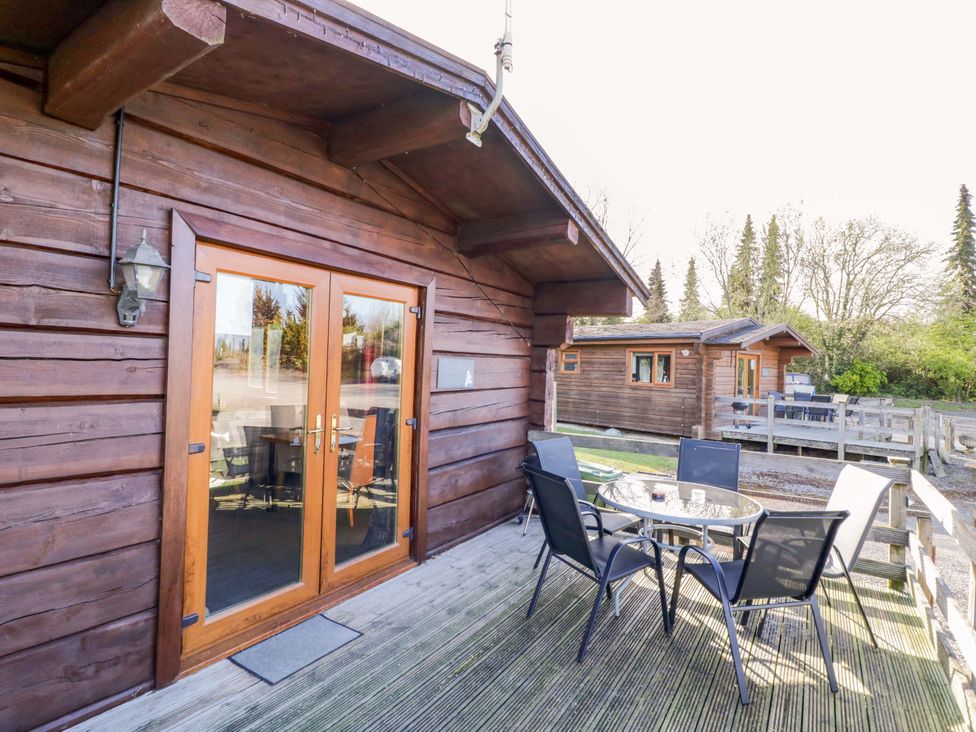 A patio area with a table and chairs at Primrose Lodge Offenham