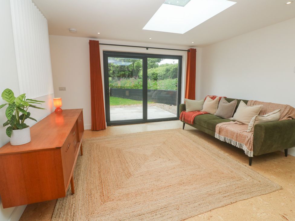 A living room with a sofa and a view of the garden at Birdsong in Gulval