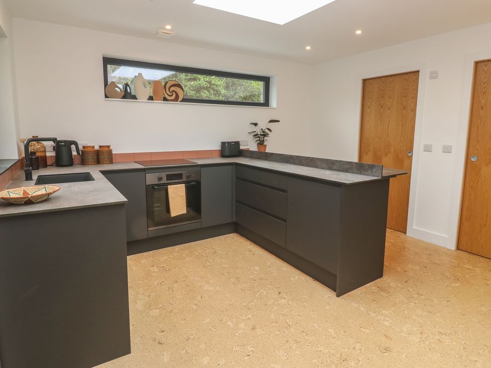 A kitchen with a black countertop and cabinets at Birdsong in Gulval