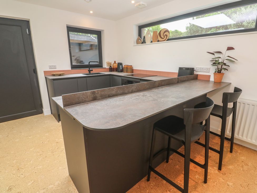 A kitchen with an island and stools at Birdsong in Gulval