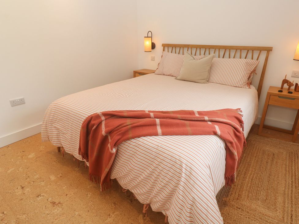 A bedroom with a bed and nightstands at Birdsong in Gulval