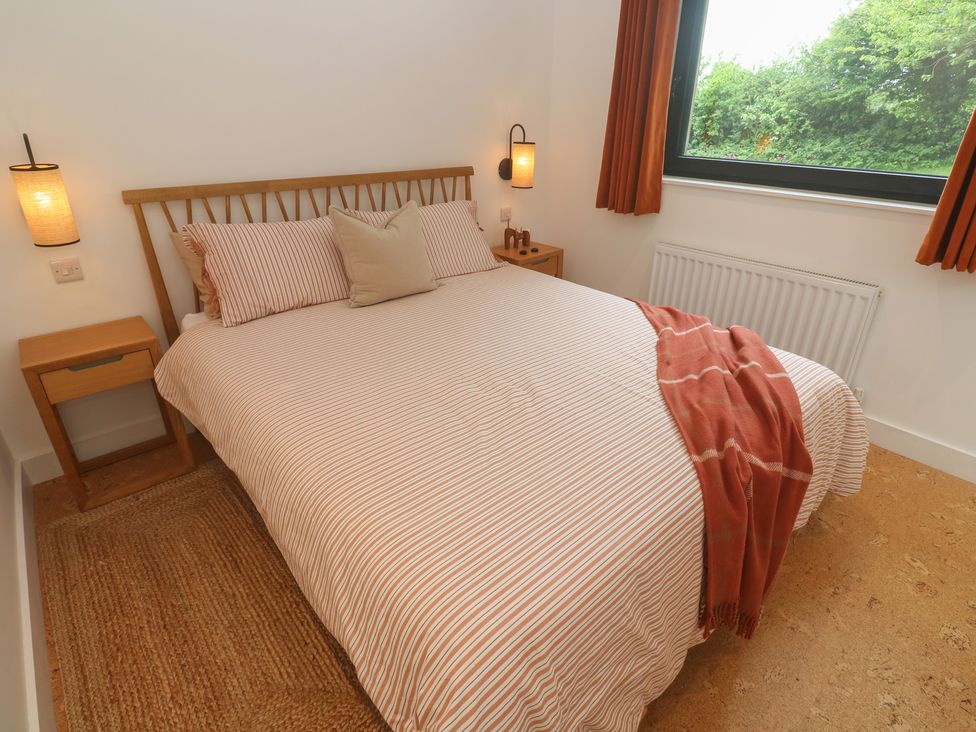 A bedroom with a bed and nightstand at Birdsong in Gulval