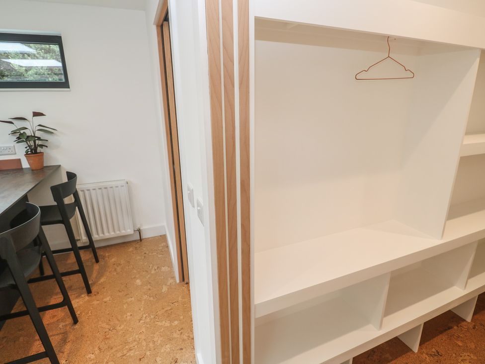 A kitchen with a shelf and table at Birdsong Gulval