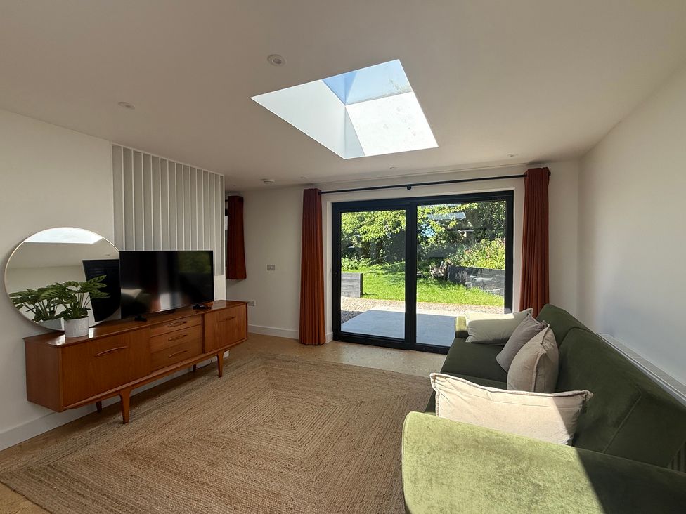 A living room with a television and sofa at Birdsong in Gulval