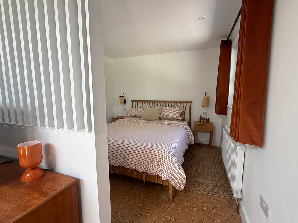 A bedroom with a bed and side table at Birdsong in Gulval