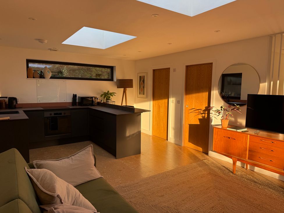 A kitchen with dark cabinets and an island at Birdsong in Gulval