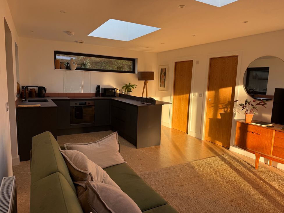 A kitchen with a sofa and doors at Birdsong in Gulval