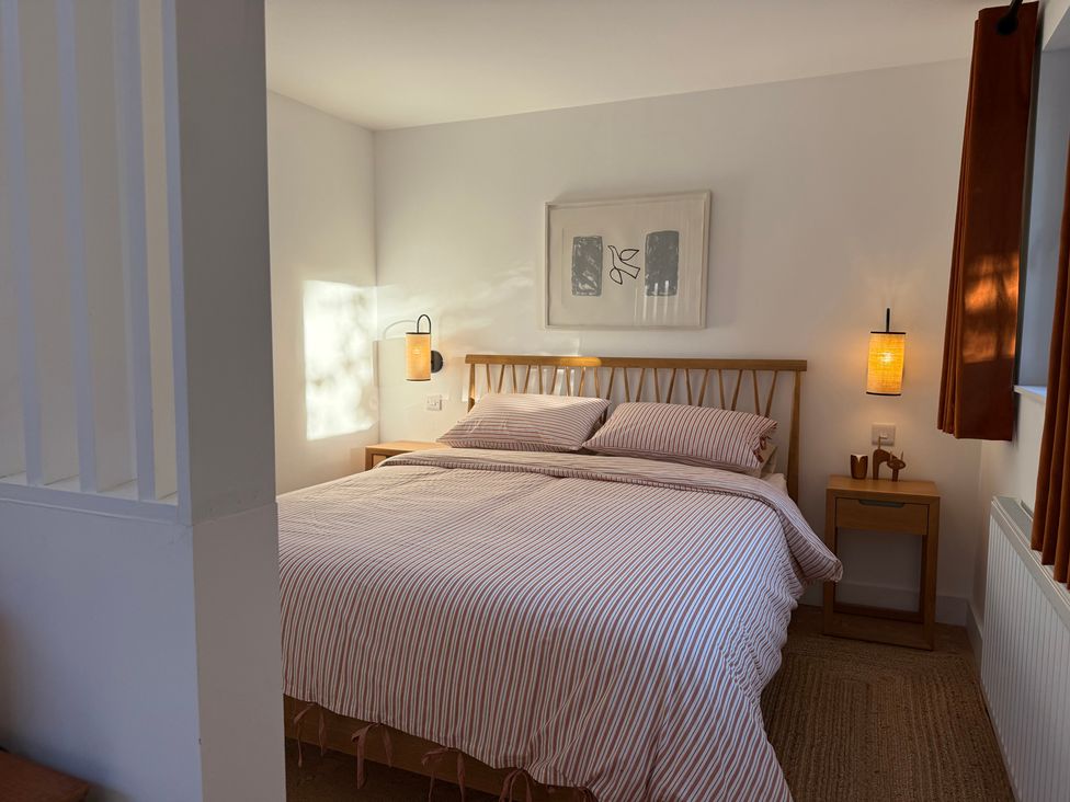 A bedroom with a bed and nightstand at Birdsong in Gulval