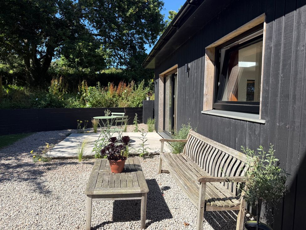 A garden with a bench and table at Birdsong in Gulval