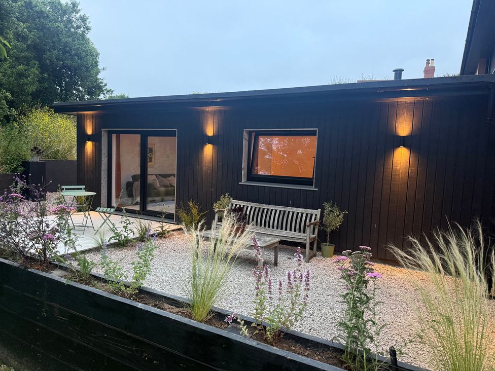 An outdoor area with a bench and plants at Birdsong in Gulval