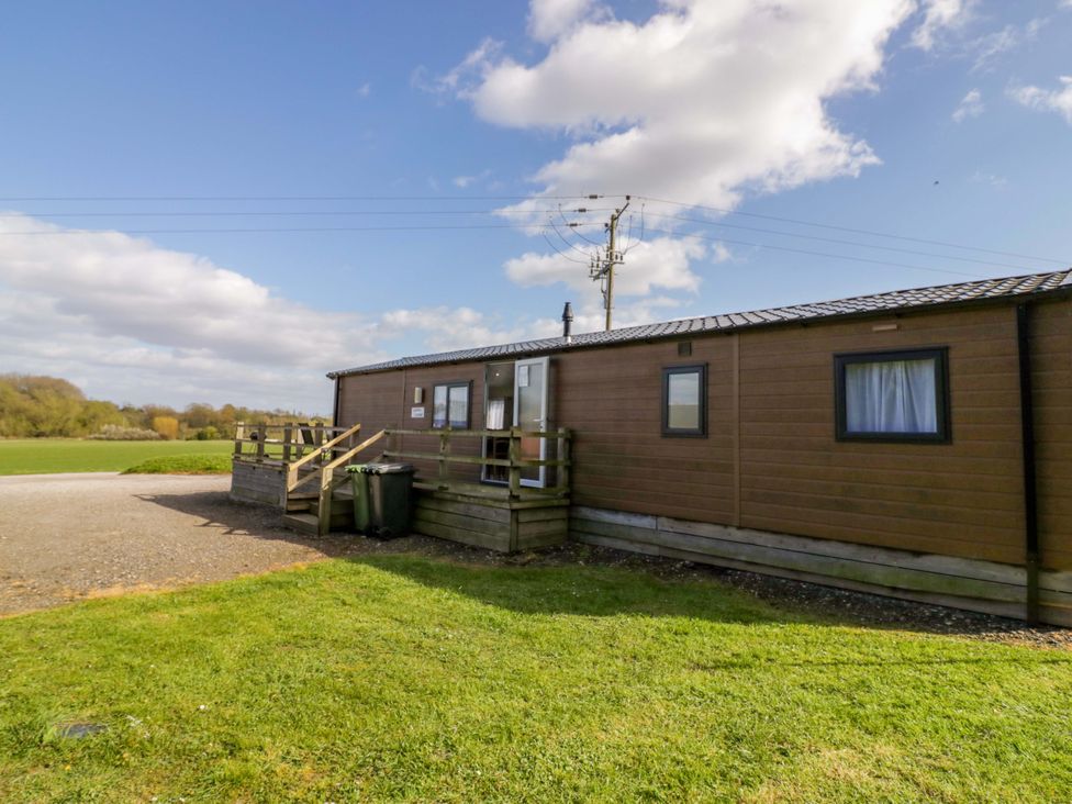 A cabin with steps and garbage bins at Laurel Lodge Offenham